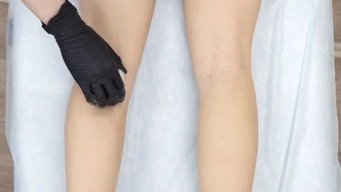 Master shugaring black gloves deftly applied the paste on the girl's feet, then Stock Footage 103046904