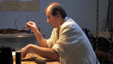 Master sits and talks about creation of shoes Stock Footage 126720435