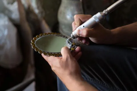 The master the special tool puts drawing on a mirror.Engraving on mirror. Stock Photos