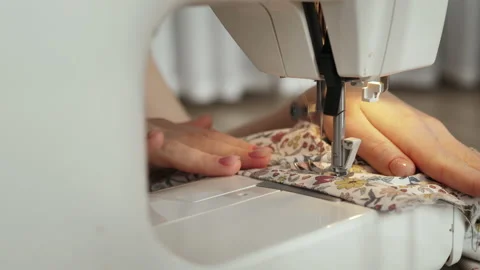 The master stitches fabric on a sewing machine. Making handmade dolls. Stock Footage 230993147