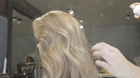 Master stylist makes the bride wedding hairstyle using spray lacquer fixing Stock Footage 107194799