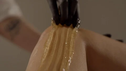 Master of sugar waxing is applying paste on leg of woman, close-up Stock Footage 89997116