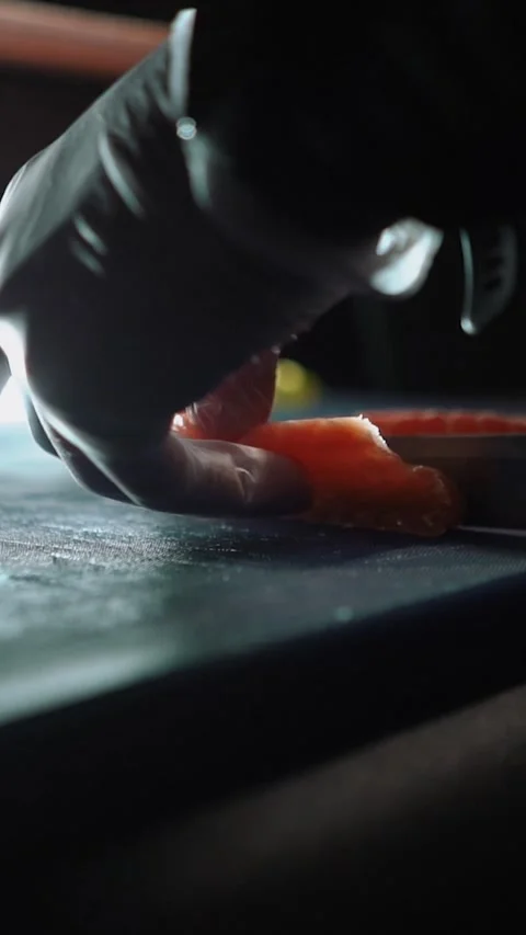 Master sushi maker makes sushi rolls from nori rice and red fish, the process of Stock Footage 256252386