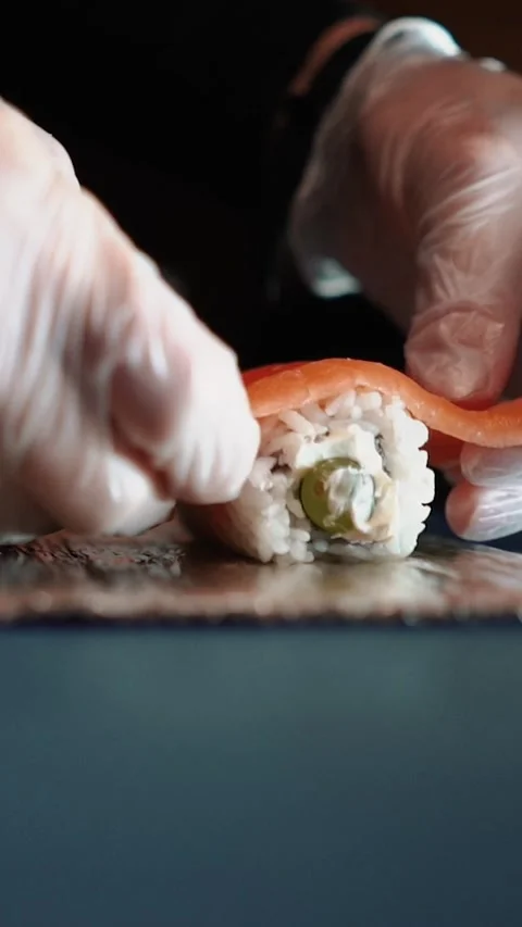 Master sushi maker makes sushi rolls from nori rice and red fish, the process of Stock Footage 256252791
