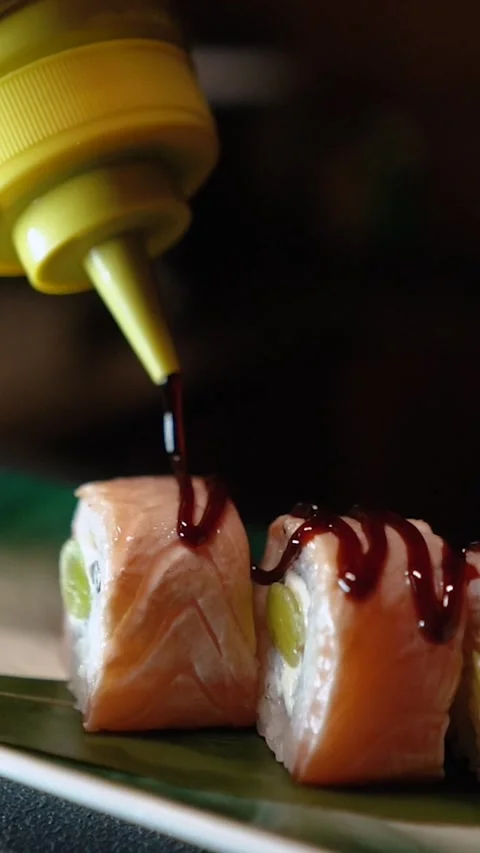 Master sushi maker makes sushi rolls from nori rice and red fish, the process of Video stock 256302925