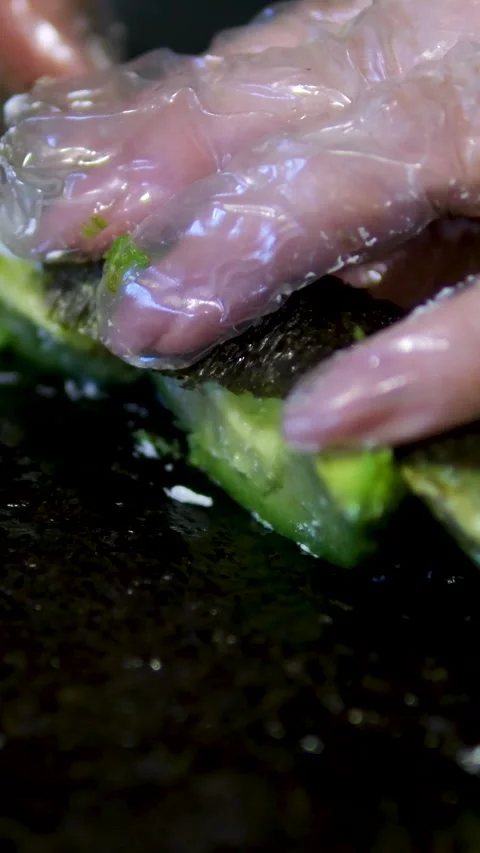 Master sushi maker makes sushi rolls from nori rice and red fish, the process of Stock-Footage 302732347