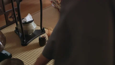 Master tea maker taking the lid off of a pot of steaming water in a traditional Stock Footage 199463597