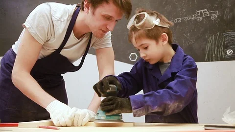 Master teaches seven-year-old child carpentry Stock Footage 102241707