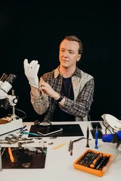 The master of technology puts on gloves at his desk Stock Photos