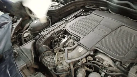 Master through the funnel starts to pour motor oil in a car engine Stock Footage 71513591