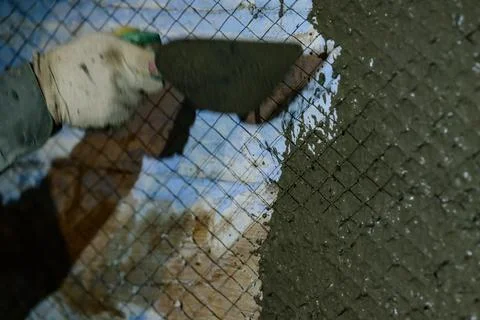 The master throws a solution of liquid concrete on the wall, the first layer  Fotos de archivo