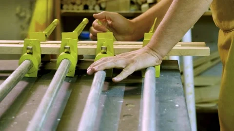 The master tightens the clamps in order to secure the parts Stock Footage 183984512