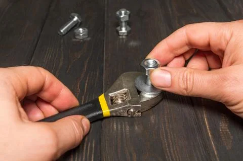 The master tightens the nut with an adjustable wrench Stock Photos