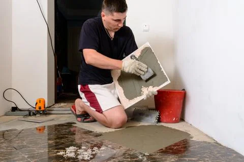 The master tile smears the mucilage solution on the marble tile 스톡 사진