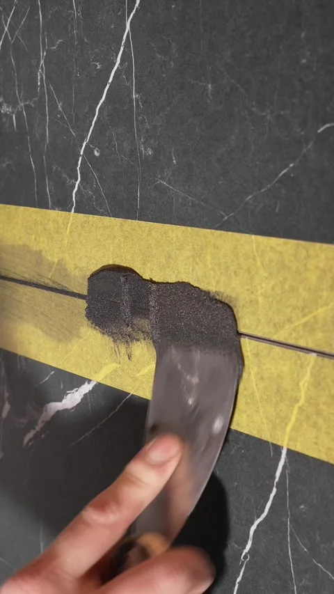 Master tiler applies epoxy grout to black tiles. grouting tile seams Stock-Footage 317902429