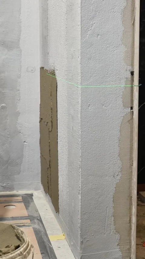Master tiler applies tile adhesive with a spatula to the wall Stock Footage 317902157