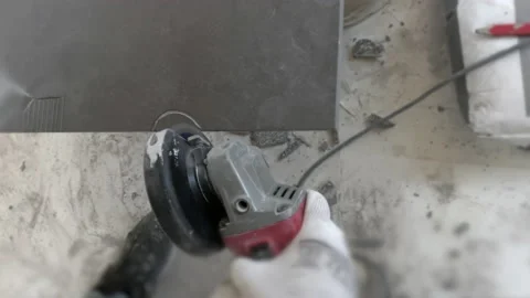 Master tiler cuts ceramic tiles with an angle grinder Video stock 155584433