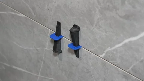 The master tiler inserts the blades into the tile leveling system Stock Footage 317901858