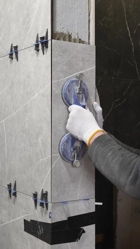 Master tiler installs gray tiles on the wall with special suction cups Stock Footage 317902406