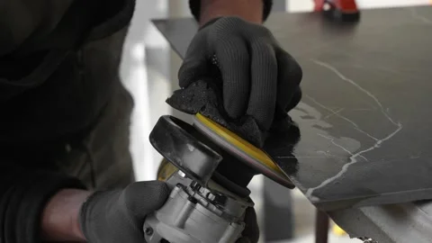 Master tiler sands black tiles with a power tool before laying Stock Footage 306019233