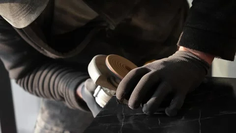 Master tiler sands black tiles with a power tool before laying Stock Footage 306019245