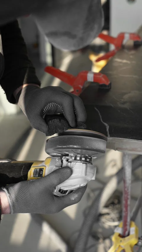 Master tiler sands black tiles with a power tool before laying Stock Footage 306019247