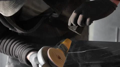Master tiler sands black tiles with a power tool before laying Stock Footage 306019257