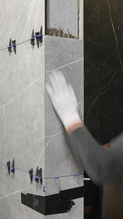 A master tiler smooths and aligns the installed tiles. Stock Footage 317902404