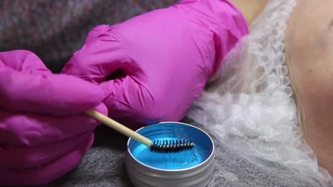 The master tries with a brush the readiness of liquid wax from a jar before appl Vidéo 156237046