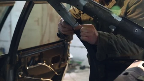 Master tries to replace a part in the car after the accident and uses bolts to Stock Footage 76210491