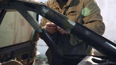 Master tries to replace a part in the car after the accident and uses bolts to Stock Footage 76226830