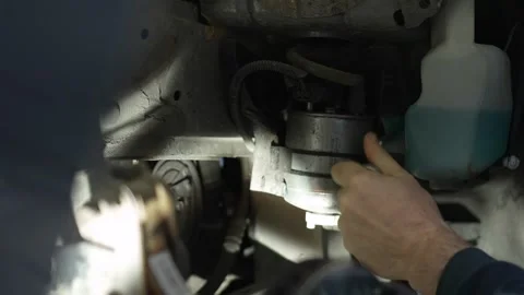 The master unscrews the bolt behind the wheel of a car with a hand tool to repla Stock Footage 320127970
