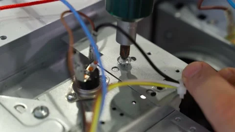 The master unscrews the screw on the microwave with a screwdriver to replace the Stock-Footage 233283689
