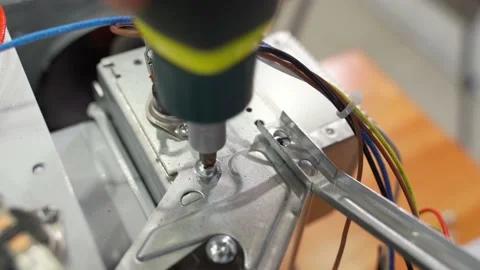 The master unscrews the screw on the microwave with a screwdriver to replace the Stock-Footage 235944075