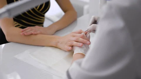 The master uses an electric machine to remove the nail polish on the hands Stock Footage 61496864