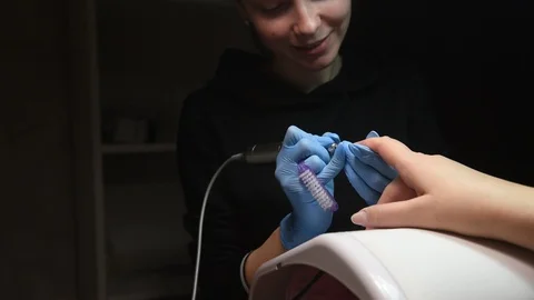 Master uses an electric machine to remove the nail polish during manicure Stock Footage 120907905