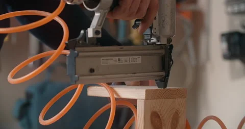 Master uses a pneumatic hammer to fasten the wooden planks, work with pneumatic Stock Footage 149268006