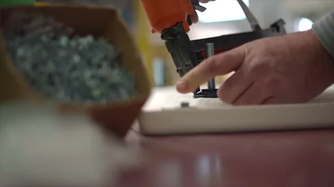 Master uses a pneumatic nail gun, production of furniture and interior items Stock Footage 168636057