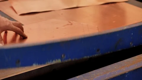 The master using a cutter, cuts the shape of the product from a sheet of copper Stock Footage 124464259
