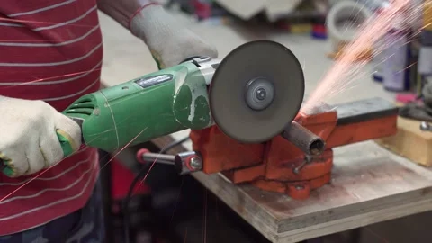 Master using grinder saws off part of metal pipe clamped in carpentry vice 스톡 동영상 149896925