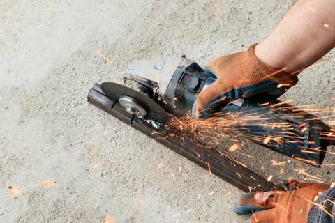 Master using grinders. a lot of sparks burn and work. cuts a square pipe. hav Stock Photos