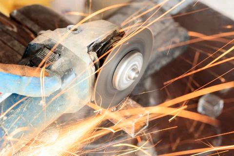 Master using grinders. a lot of sparks burn and work. cuts a square pipe. hav Stock Photos