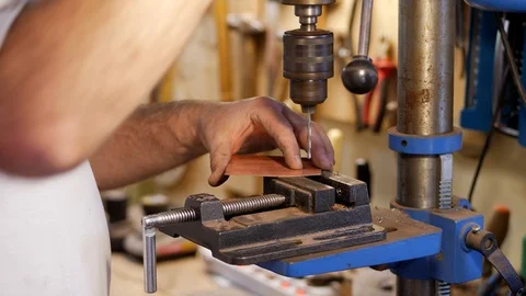 The master using a milling machine makes a hole on a piece of copper Stock Footage 124466517