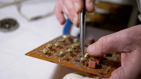 Master, Using Tweezers, Inserts Radio Parts, Transistors in Board, on Scheme. 4K Video stock 150099126