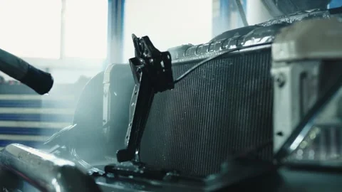 A master washes a car radiator using a high-pressure washer, cleaning the Stock Footage 285642791