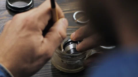 The master washes the inner lens housing with a brush in a special liquid. 4k Stock Footage 119731399