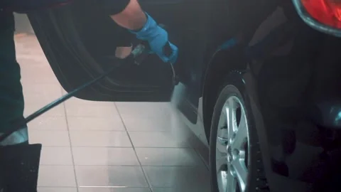 Master washes inner surface of door od sedan with water hose in service closeup Stock Footage 155965463