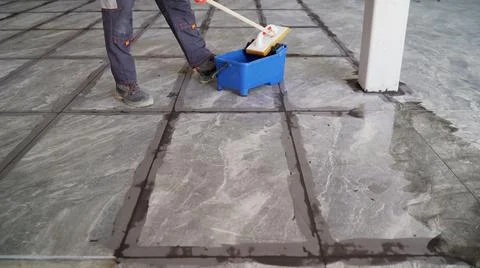 The master washes the tiles after grouting. The tiler washes the tiles on the Stock Photos