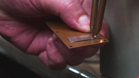 The master welds two pieces of metal using resistance welding. The process of Stock Footage 130779554