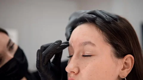 Master wipes his eyebrows with an antiseptic Stockbeeldmateriaal 146530606